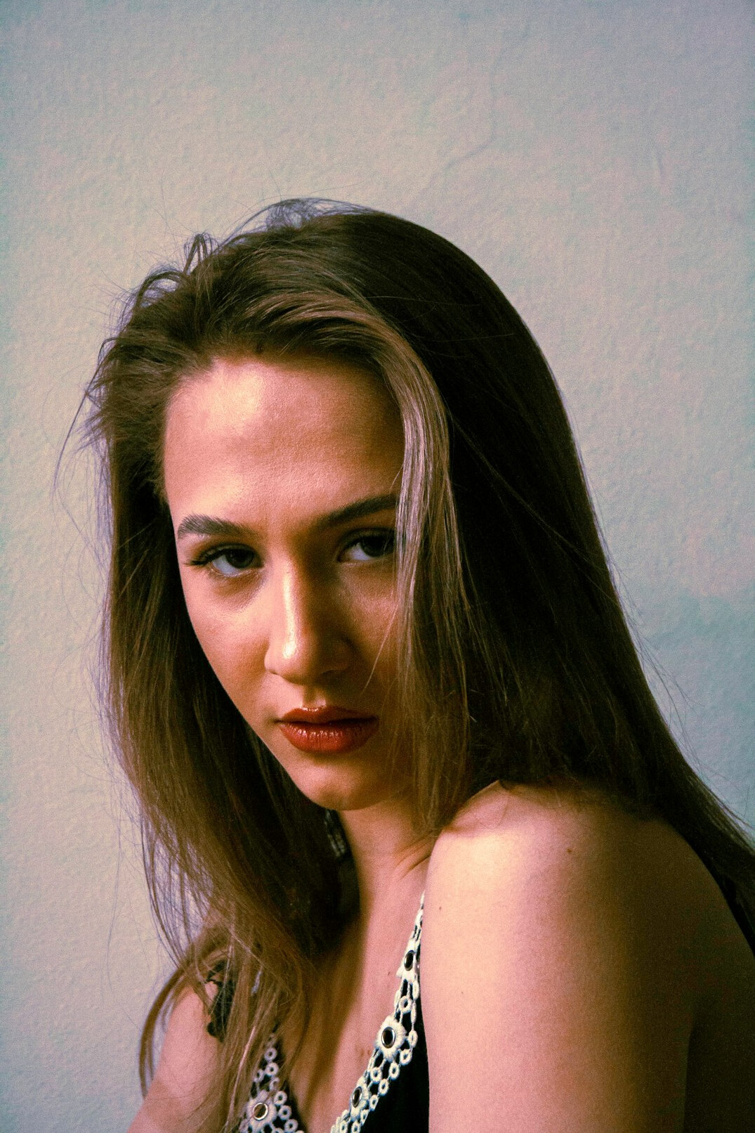 Studio portrait of a young woman with shoulder-length hair smiling