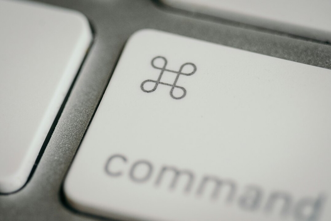 Close-up of hands typing code on a laptop keyboard