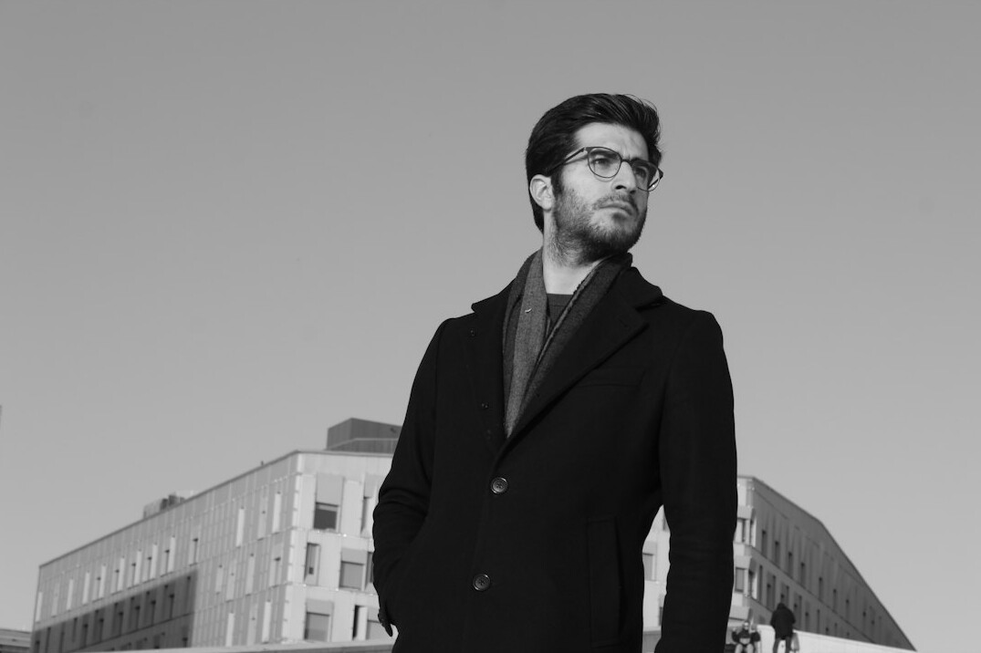 Studio portrait of a bearded man with glasses in business casual attire